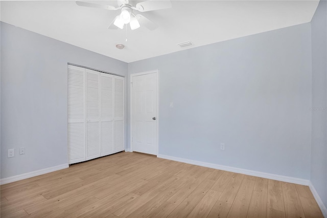 unfurnished bedroom featuring light wood-type flooring, visible vents, baseboards, and a closet