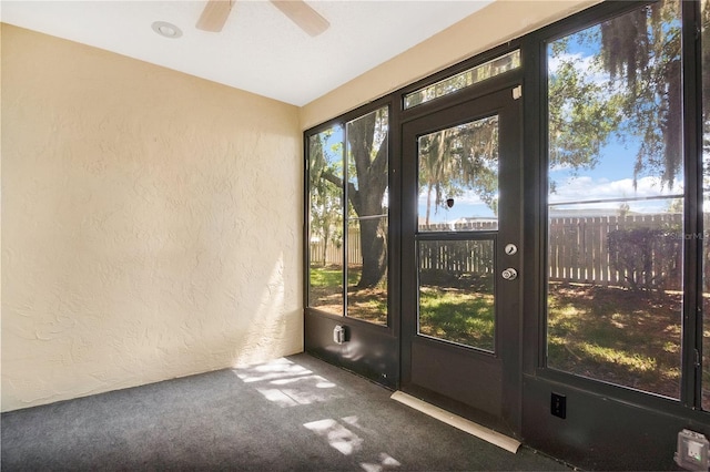 unfurnished sunroom featuring ceiling fan