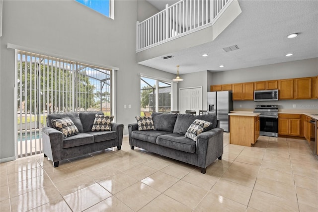 tiled living room featuring a textured ceiling and a high ceiling