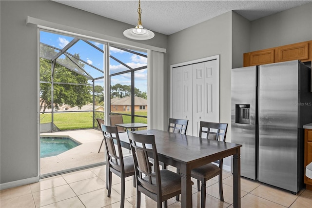 dining room with a wealth of natural light, a textured ceiling, and light tile floors