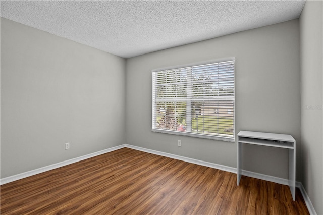 spare room featuring wood-type flooring and a textured ceiling