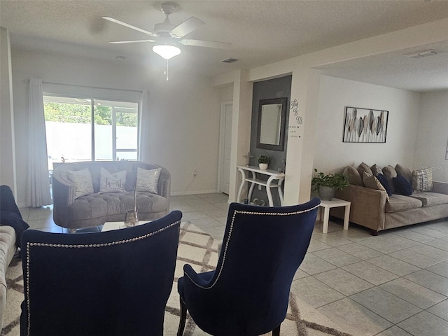 living room featuring a textured ceiling, ceiling fan, and light tile floors