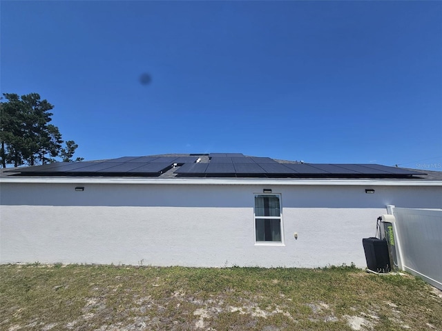 view of side of home featuring solar panels