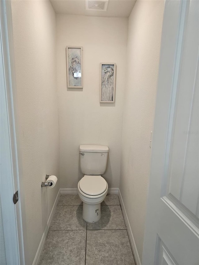 bathroom featuring tile floors and toilet