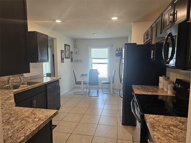 kitchen featuring black dishwasher, light stone counters, light tile floors, sink, and range with electric cooktop