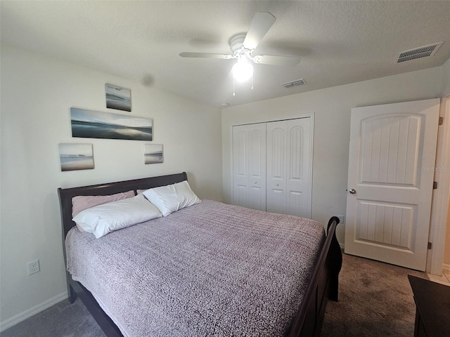 bedroom featuring a closet, a textured ceiling, dark carpet, and ceiling fan