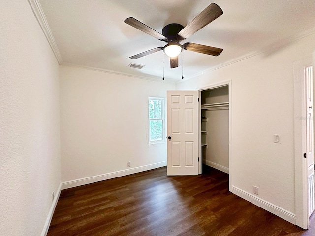 unfurnished bedroom featuring crown molding, dark wood-type flooring, a closet, and ceiling fan