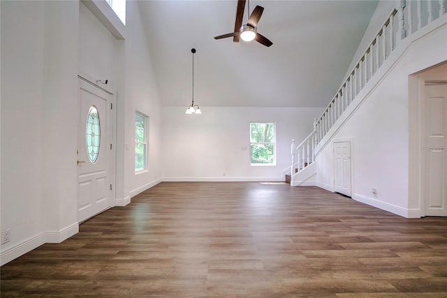 foyer with ceiling fan, dark hardwood / wood-style flooring, and a towering ceiling