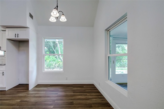 unfurnished dining area featuring a notable chandelier, a wealth of natural light, dark hardwood / wood-style floors, and lofted ceiling