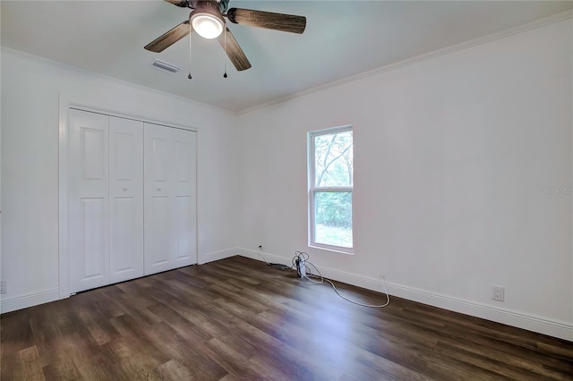 unfurnished bedroom featuring ceiling fan, a closet, dark hardwood / wood-style flooring, and crown molding