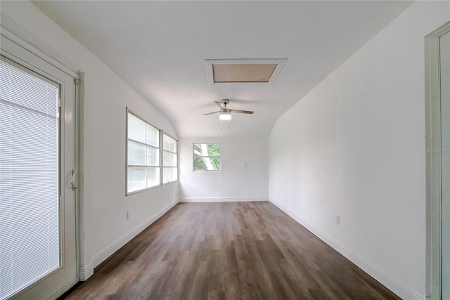 spare room featuring dark wood-type flooring and vaulted ceiling