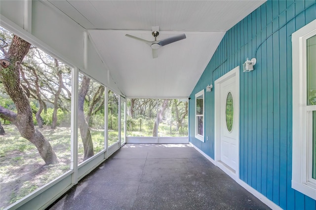 unfurnished sunroom with ceiling fan and vaulted ceiling