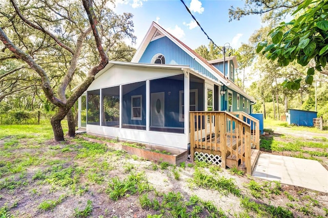 rear view of property featuring a sunroom