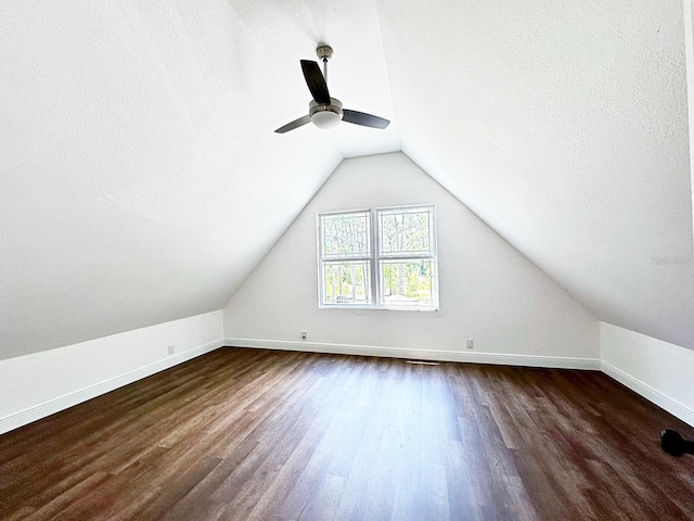 additional living space featuring ceiling fan, a textured ceiling, lofted ceiling, and dark hardwood / wood-style flooring