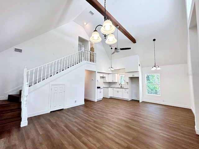 unfurnished living room with dark hardwood / wood-style flooring, sink, beam ceiling, high vaulted ceiling, and a chandelier