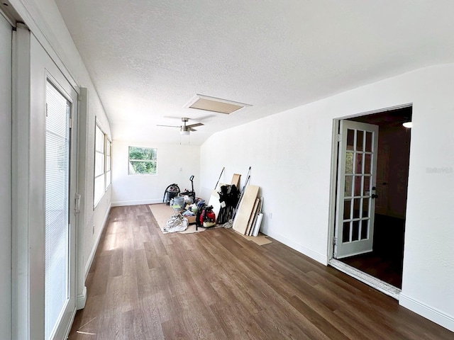 workout area with a textured ceiling, lofted ceiling, and hardwood / wood-style floors