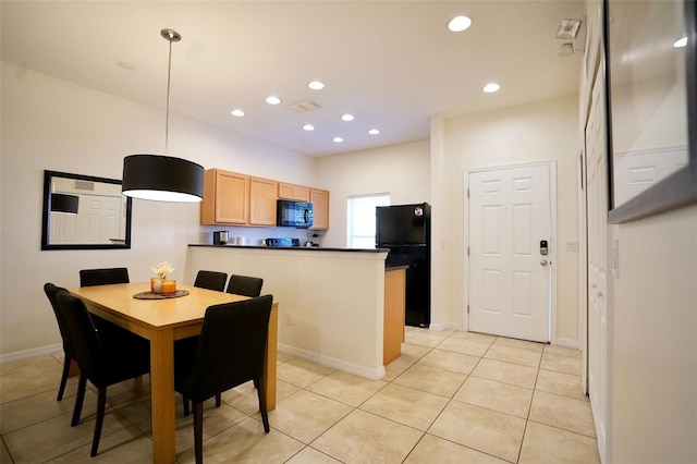 kitchen with hanging light fixtures, black appliances, and light tile floors