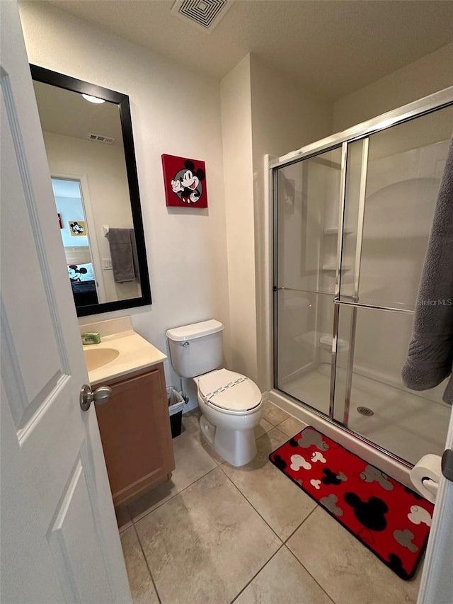 bathroom with an enclosed shower, toilet, tile flooring, and vanity