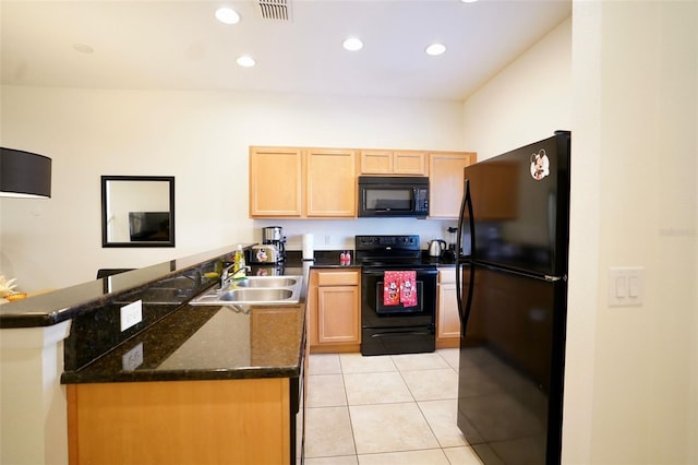 kitchen featuring dark stone countertops, sink, light tile flooring, black appliances, and kitchen peninsula