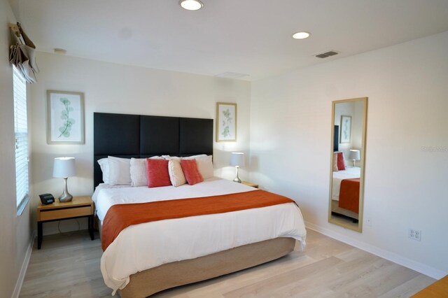 bedroom with light wood-type flooring and multiple windows