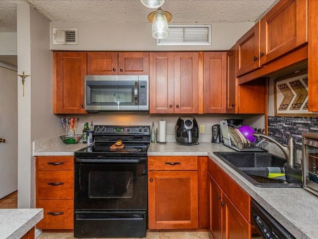 kitchen with sink, black appliances, and a textured ceiling