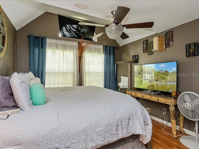 bedroom featuring lofted ceiling, ceiling fan, hardwood / wood-style flooring, and a textured ceiling