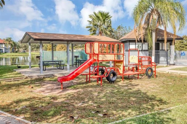 view of jungle gym with a lawn and a water view