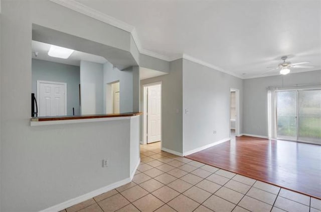 empty room featuring ceiling fan, crown molding, and light tile floors