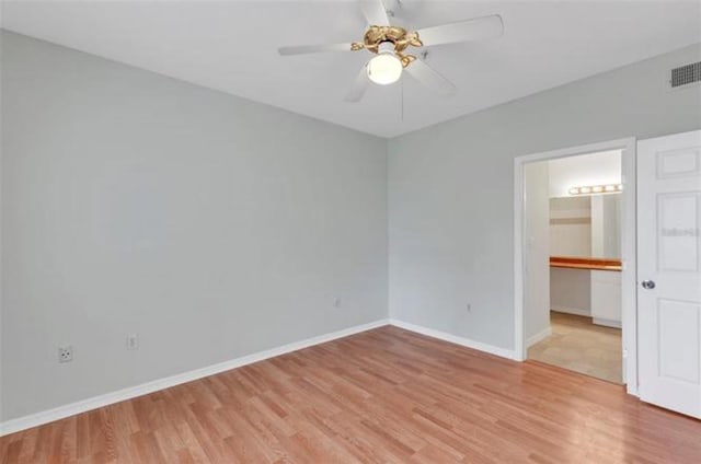 unfurnished bedroom with a spacious closet, ceiling fan, and light wood-type flooring