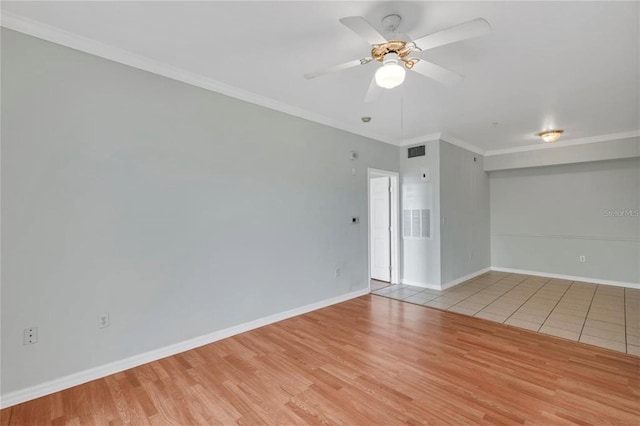 tiled empty room featuring ornamental molding and ceiling fan