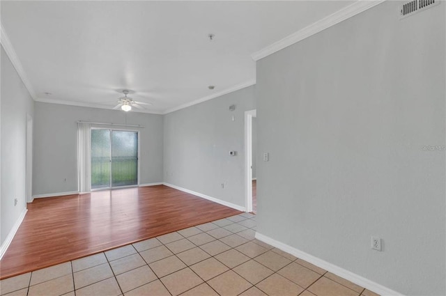 tiled spare room featuring ceiling fan and crown molding