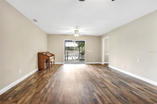 spare room with dark wood-type flooring and ceiling fan