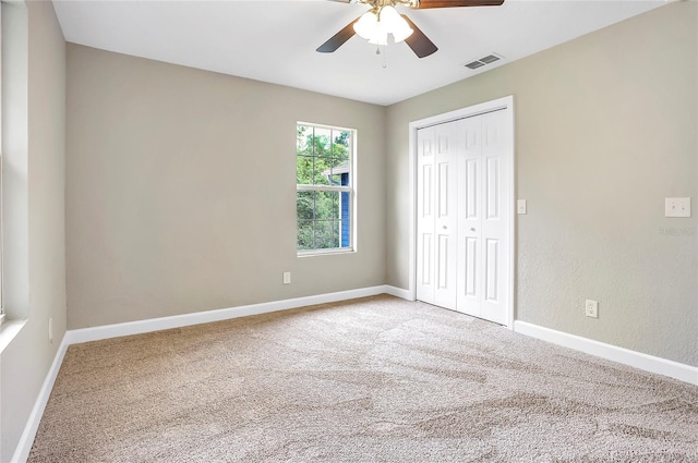 unfurnished bedroom with ceiling fan, carpet flooring, and a closet