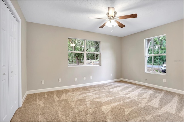 unfurnished bedroom featuring a closet, carpet floors, and ceiling fan