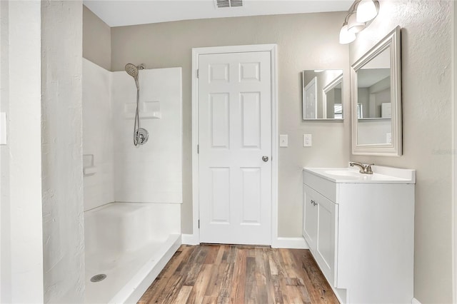 bathroom with vanity, walk in shower, and hardwood / wood-style flooring