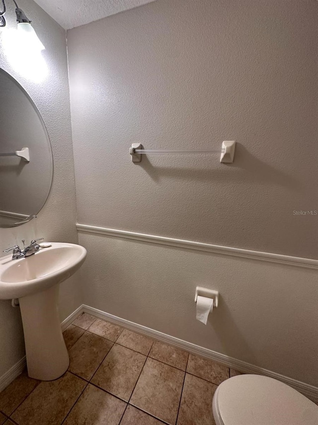 bathroom featuring toilet and tile flooring