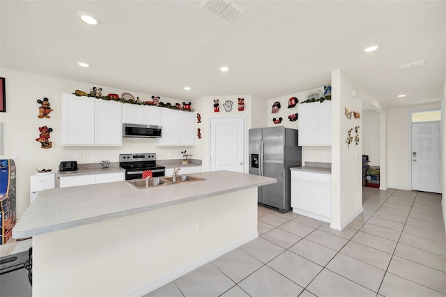 kitchen featuring appliances with stainless steel finishes, sink, an island with sink, and white cabinetry