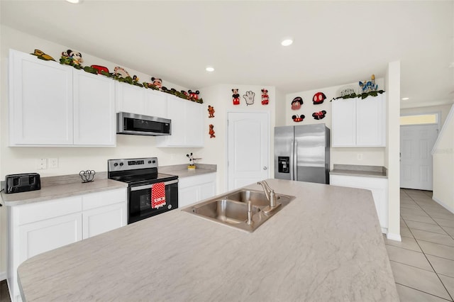 kitchen with light tile floors, stainless steel appliances, white cabinets, and sink