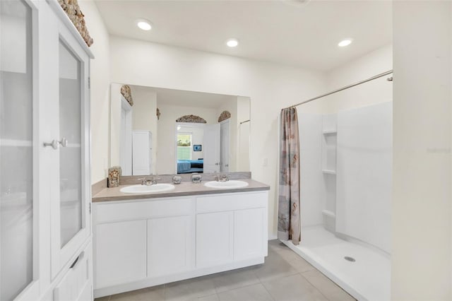 bathroom featuring dual sinks, tile floors, walk in shower, and large vanity