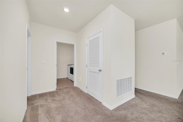 unfurnished bedroom featuring light colored carpet and a closet