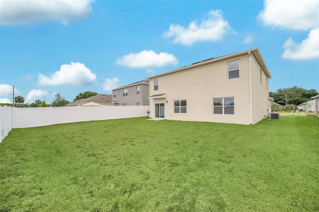 back of house with central AC and a lawn