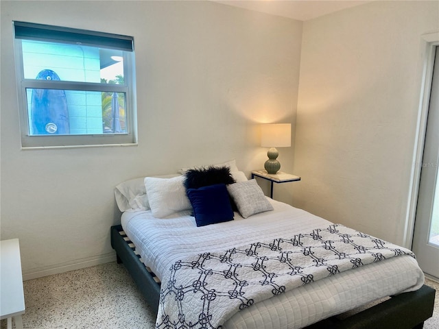 bedroom featuring speckled floor and baseboards