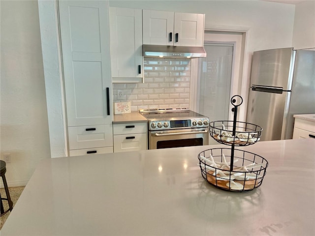 kitchen featuring decorative backsplash, appliances with stainless steel finishes, and white cabinets