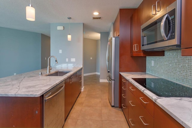 kitchen featuring light tile flooring, sink, stainless steel appliances, and pendant lighting