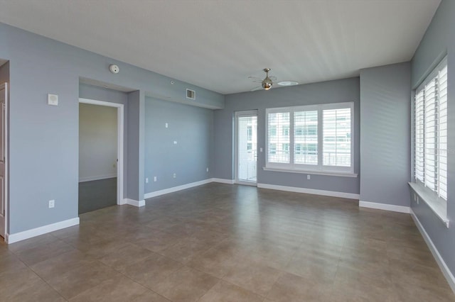 tiled empty room featuring ceiling fan