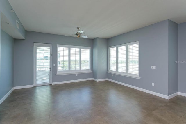 tiled empty room with ceiling fan and a healthy amount of sunlight