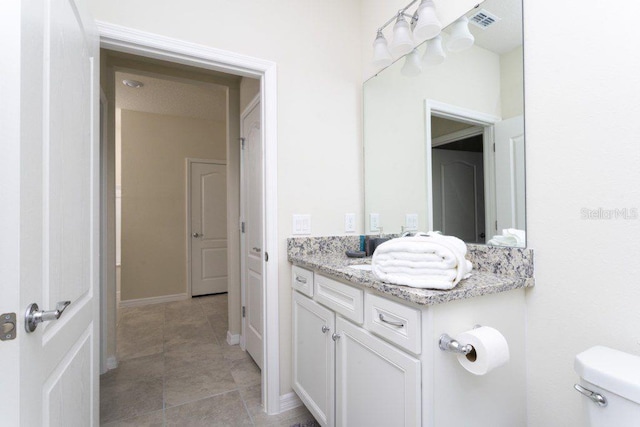 bathroom with tile flooring, vanity, and toilet