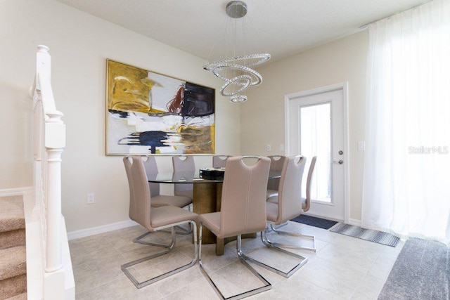 dining space with light tile floors and an inviting chandelier