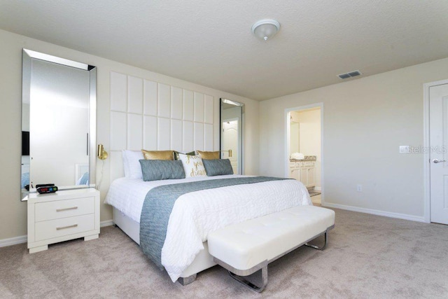 bedroom with light carpet and ensuite bathroom