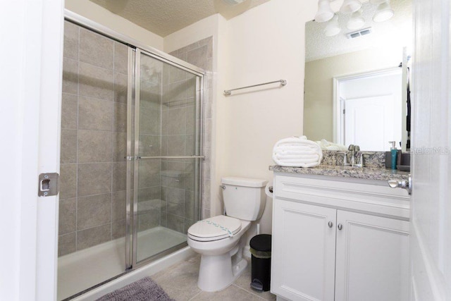 bathroom with an enclosed shower, large vanity, tile flooring, toilet, and a textured ceiling